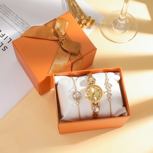 Gros plan sur une montre à quartz dorée et bracelets LOVE dans un coffret cadeau orange