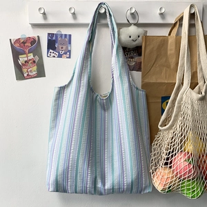 Gros plan d'un sac cabas en seersucker à rayures bleues suspendu dans une pièce