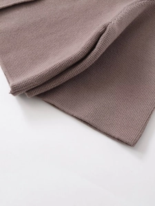 Vue détaillée du gilet en maille taupe montrant la texture du tricot plat et fin