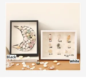 Dettaglio di cornici in legno fai-da-te con conchiglie in design minimalisti bianco e nero