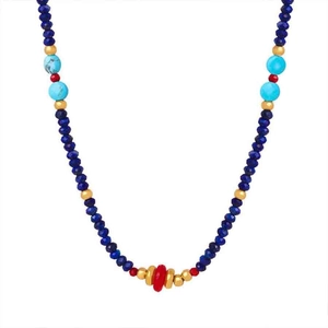 Detail of bohemian colorful beaded necklace with blue faceted beads and red stone focal