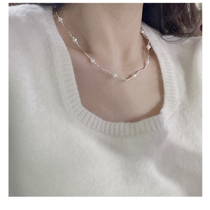 Close-up of minimalist S925 sterling silver chain with small white freshwater pearls