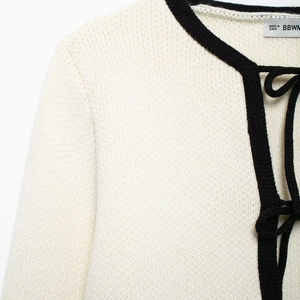 Gilet en maille beige élégant avec bordure noire contrastée et lien pour femme