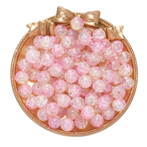 Pink crackle glass beads for DIY jewelry making displayed on a gold tray with a bow