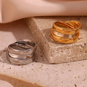 Macro detail of double-layer crossed rings in gold and silver finish on stone