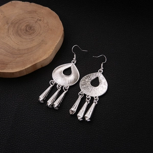 Detail view of silver bohemian tassel earrings with hollow teardrop leaf pendants