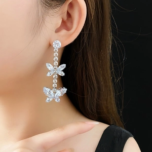 Détail des boucles d'oreilles papillon en argent avec pierres en zircon sur modèle