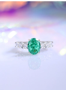 Macro shot of oval green gemstone ring on s925 sterling silver band with white zircon
