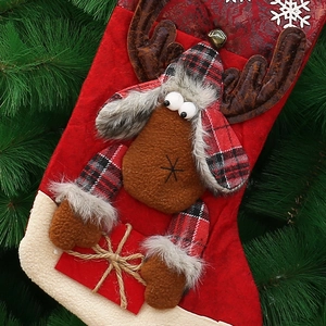 Close-up of 3D reindeer Christmas stocking with faux fur details on green tree background