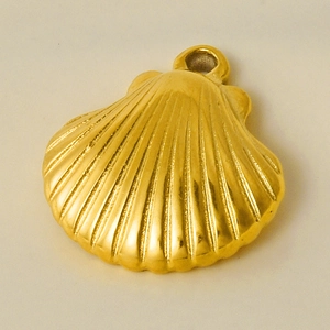 Macro shot of gold shell charm pendant with detailed texture and hanging ring attachment