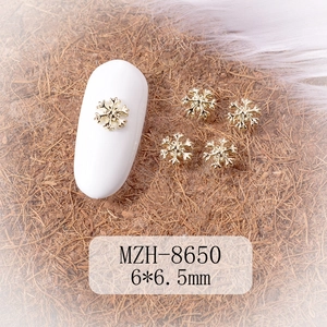 Detailed close-up of golden snowflake nail charms sized 6x6.5mm for winter manicure DIY