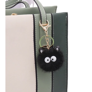 Faux mink fur black coal ball bag charm with large eyes on leather handbag