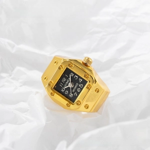 Macro detail of vintage gold-plated ring watch with black square dial and metal rivets