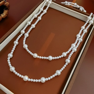 Detailed view of elegant layered white pearl necklace in a vintage brown jewelry gift box