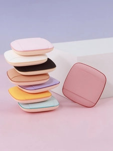 Macro detail of multi-colored square finger powder puffs with soft ribbon strap
