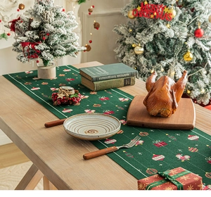 Dettaglio del runner da tavola natalizio verde con motivi di Babbo Natale e regali