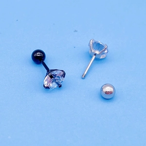 Detail of round zircon earrings with four-prong setting and screw back fasteners
