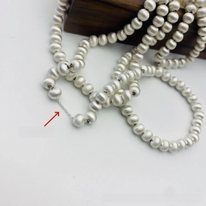 Vue détaillée du collier à billes argentées avec texture brossée mate et chaîne intérieure