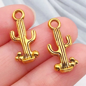 Detailaufnahme von zwei goldfarbenen Kaktus-Anhängern für Western-Cowboy-Schmuck zum Selbermachen