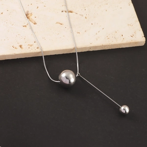 Detailed close-up of a silver stainless steel Y-shaped necklace with round bead pendants