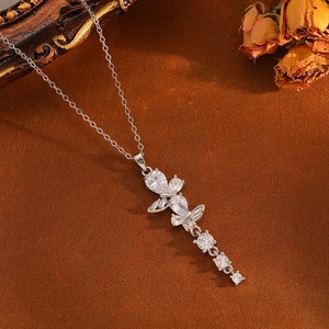 Elegant silver butterfly tassel necklace with sparkling zircon drop pendants on warm background
