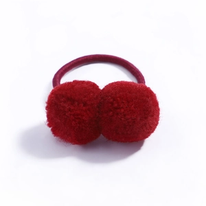 Detail of red faux fur double pom pom hair tie with elastic band on white background