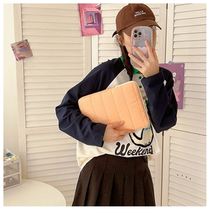 Quilted apricot laptop sleeve shown in a lifestyle mirror selfie for everyday use