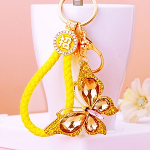Detail of crystal butterfly keychain with gold plating and woven tassel charm