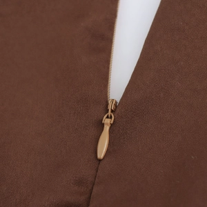 Detail of elegant brown chiffon dress featuring an invisible zipper and twill texture