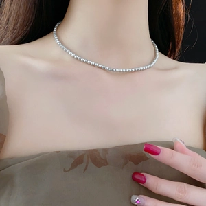 Details einer silbernen Perlenkette am Model für einen eleganten Vintage-Look