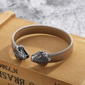 Detail of punk style snake head flexible steel bracelet on a vintage wooden box