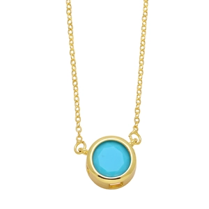 Gros plan d'un collier à pendentif rond minimaliste avec pierre bleue et serti doré