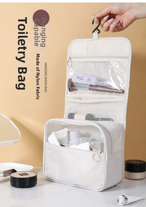 Detail view of cream hanging wash bag with hooks and multiple storage compartments