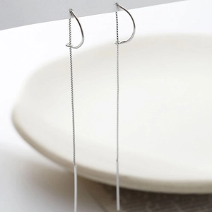 Macro detail of silver long threader earrings with fine chains and vertical bars