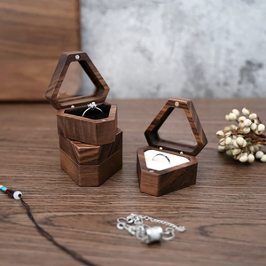 Macro shot of hexagonal walnut wood ring box with black and white interior lining