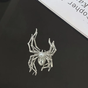 Detailed close-up of a silver spider hair claw clip with pearl and rhinestone inlay