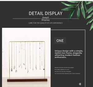 Detail of golden metal frame necklace stand with solid wood base for jewelry storage