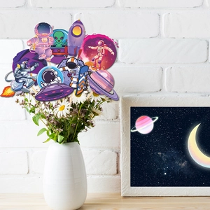 Space theme cake toppers with astronauts and rockets in a white ceramic vase decoration