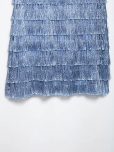 Close-up of layered blue fringe detailing with metallic shimmer on vacation dress