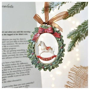 Detail of Christmas rocking horse ornament with resin finish and red bow hanging on ribbon