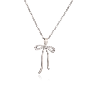 Silver bow necklace with sparkling zircon pendant on white background with reflection
