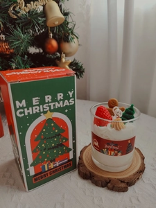 Detail of Christmas scented candle with strawberry decoration in a festive gift box