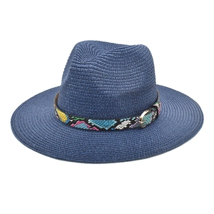 Detail of navy blue straw fedora with textured decorative band and golden metal buckle
