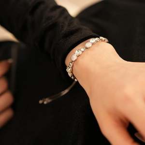 Bracelet argenté réglable avec pierres œil-de-chat et cristaux portés au poignet