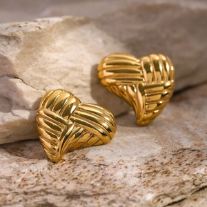 Textured 18k gold stainless steel heart earrings on natural stone background