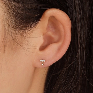 Close-up of elegant gold s925 silver stud earrings with marquise diamonds on ear