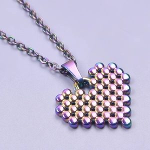 Macro detail of rainbow stainless steel heart necklace with textured metallic bead matrix