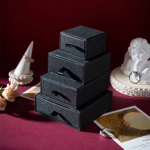 Stack of black frosted drawer jewelry boxes in four sizes with ribbon handles