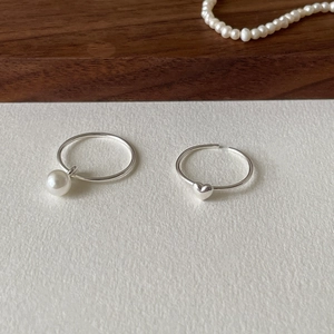925 silver ring set featuring a pearl pendant and heart charm on white textured background