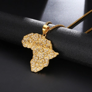 Macro shot of gold-plated Africa map pendant with sparkling crystals and embossed lettering
